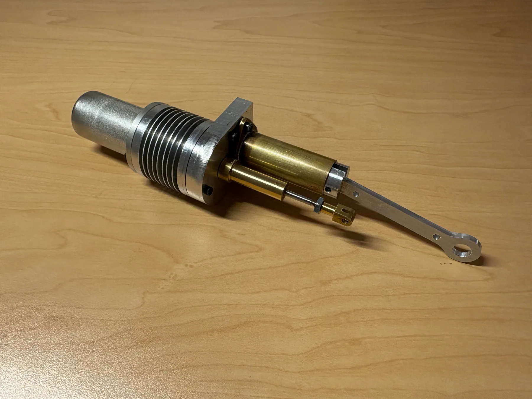 Machined Stirling engine component with threaded features.